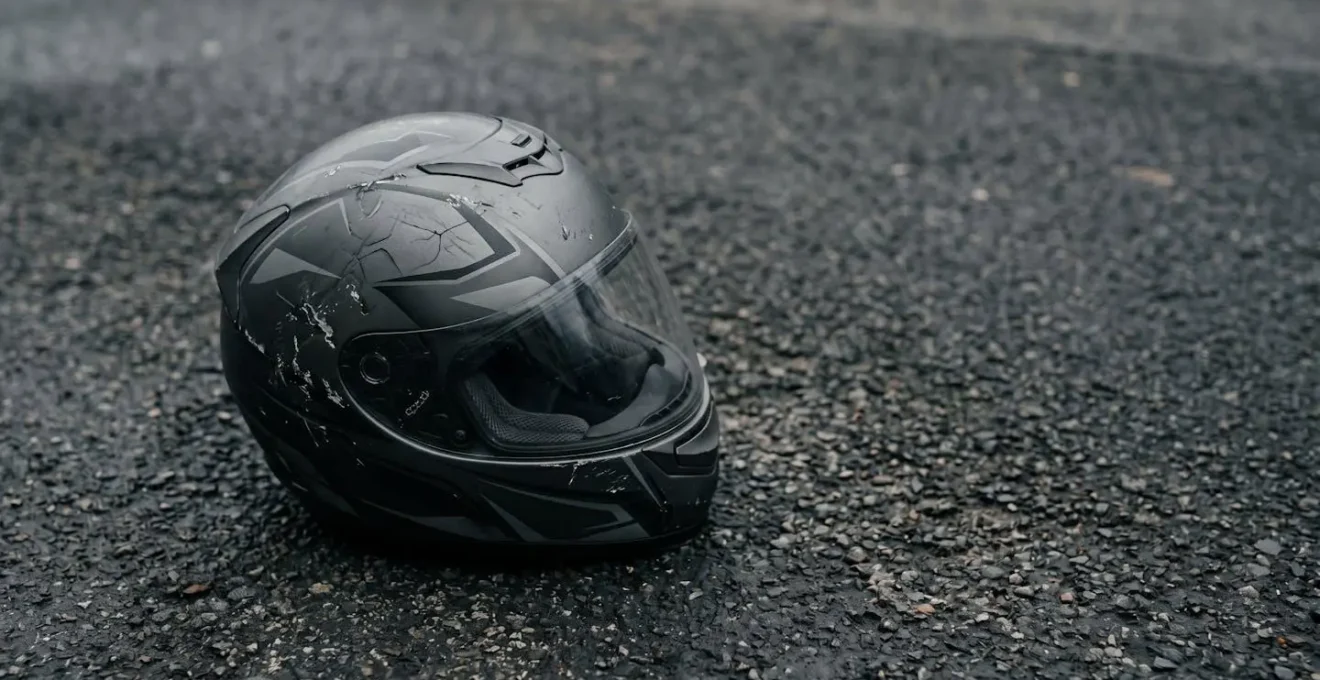 Casque de moto endommagé après un accident illustrant les risques d'un équipement non homologué
